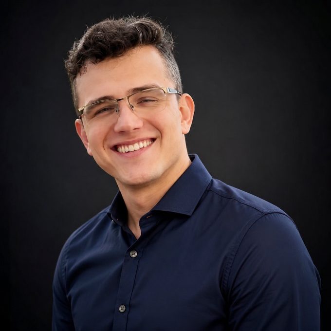 Marco Gouveia, de camisa azul-marinho, sorrindo.